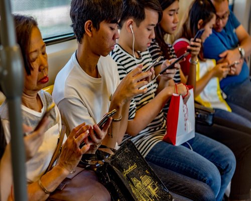 Commuter looking at smartphone while riding modern public transport